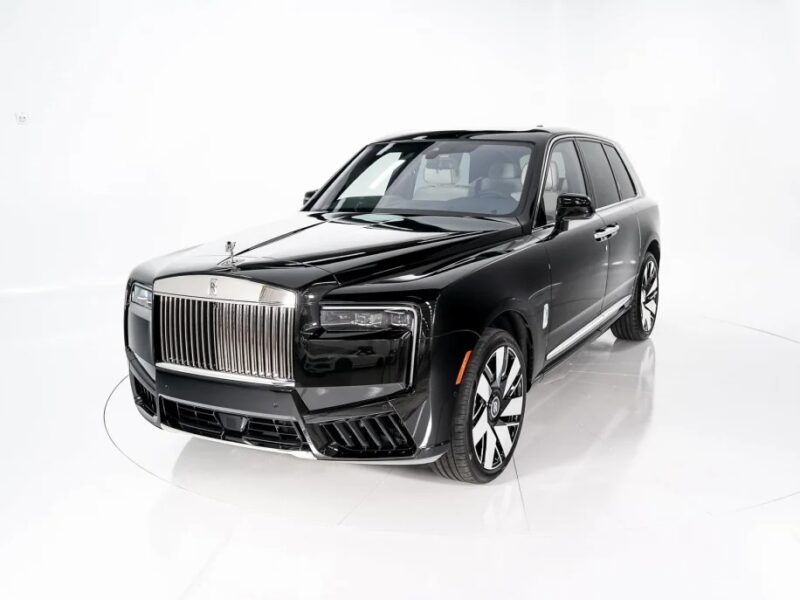 In a pristine white studio, the Rolls-Royce Cullinan epitomizes pinnacle luxury. Its sleek design and prominent chrome grille distinguish this black SUV as the ultimate statement of elegance and sophistication.