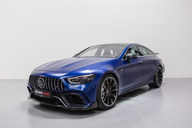 A unique creation, this blue high-performance sports car with black wheels sits against a white background. The sleek design and prominent front grille make it look like it's ready to roar out of the garage, capturing attention with its custom flair.