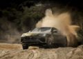 The Lamborghini Urus SE, a luxury hybrid SUV, powers through the sandy terrain of Nardò, kicking up an impressive cloud of dust.