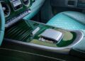 Close-up of a custom Mercedes-AMG central console featuring green quilted leather, control panel with buttons, and a touchpad.