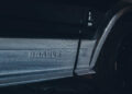 Close-up of a Custom Rolls-Royce with "BRABUS" embossed on the side panel, showcasing sleek carbon fiber detailing and part of a wheel.