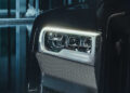 Close-up of a custom BRABUS car headlight with LED strips and a textured grille, set against a dimly lit background.