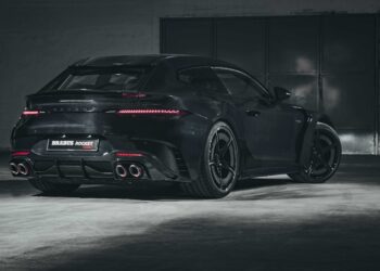 A black Brabus Rocket 900 Hyper GT car is parked in a dimly lit garage, viewed from the rear side.