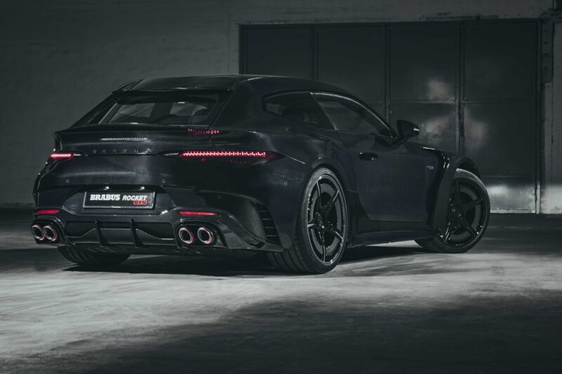 A black Brabus Rocket 900 Hyper GT car is parked in a dimly lit garage, viewed from the rear side.