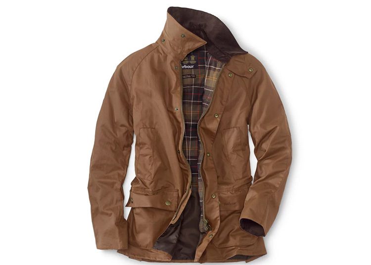 This brown waxed jacket, featured in the duPont REGISTRY's Fall Shopping Guide, boasts a plaid lining, buttoned front, and multiple pockets—perfect for the cooler months.