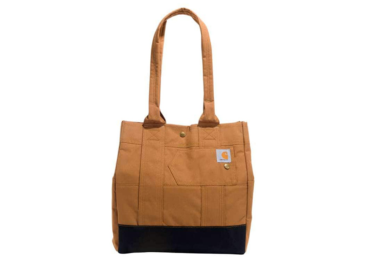 A brown and black tote bag with two handles, perfect for your fall shopping guide, featuring a small logo patch on the front.