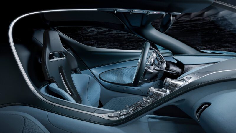 The interior of a luxury car, reminiscent of a Bugatti, showcases sleek blue upholstery, a modern steering wheel, and futuristic controls—an experience that feels crafted for the next century.