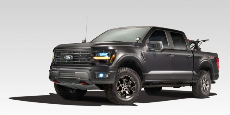A custom Ford pickup truck with rugged tires is parked, showcasing its SEMA 2024 vibe with a bicycle in the bed, flaunting Custom Garage Packages.