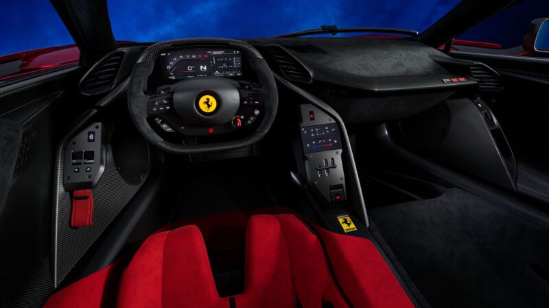 The interior of the Ferrari sports car boasts a steering wheel with controls, a digital dashboard, red and black seats, and sleek carbon fiber surfaces, all powered by the throaty roar of a V6 F80 Hypercar engine.