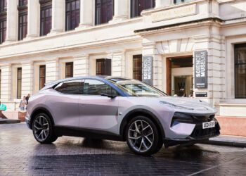 A sleek Eletre Hyper SUV, reminiscent of Lotus design, is parked outside a building adorned with "Science Museum" signs.