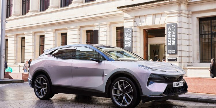 A sleek Eletre Hyper SUV, reminiscent of Lotus design, is parked outside a building adorned with "Science Museum" signs.