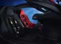 The interior of this hypercar showcases two racing seats with harnesses, featuring a sleek black and red design against a blue-lit background, reminiscent of the iconic F80 Ferrari aesthetic.