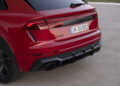 Rear view of a red Audi RS Q8 parked on a concrete surface, highlighting its taillights, exhaust, and branding. This powerful combustion engine showcases the hallmark features of an elite Audi Sport model.