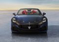 A black Maserati GranCabrio Trofeo, boasting red interior seats, sits elegantly on a reflective surface against a clear sky, embodying the spirit of Auto e Moto d'Epoca.