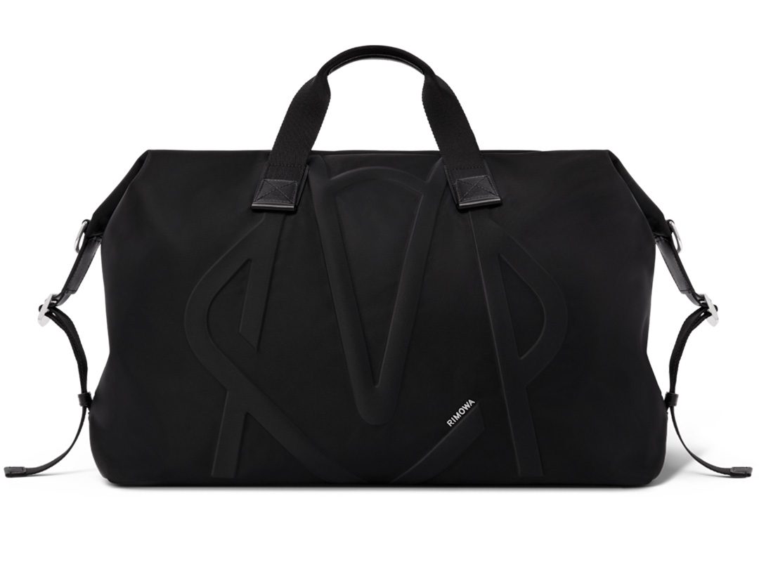 A stylish black duffel bag with sturdy handles and a sleek, minimalist design, perfect for any road trip.