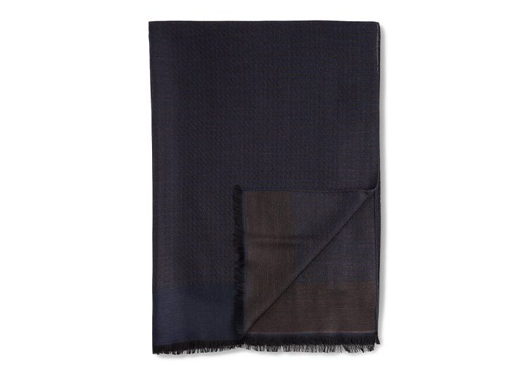 A dark-colored, folded fabric with a fringed edge, perfect for the cooler months, displayed against a plain background.