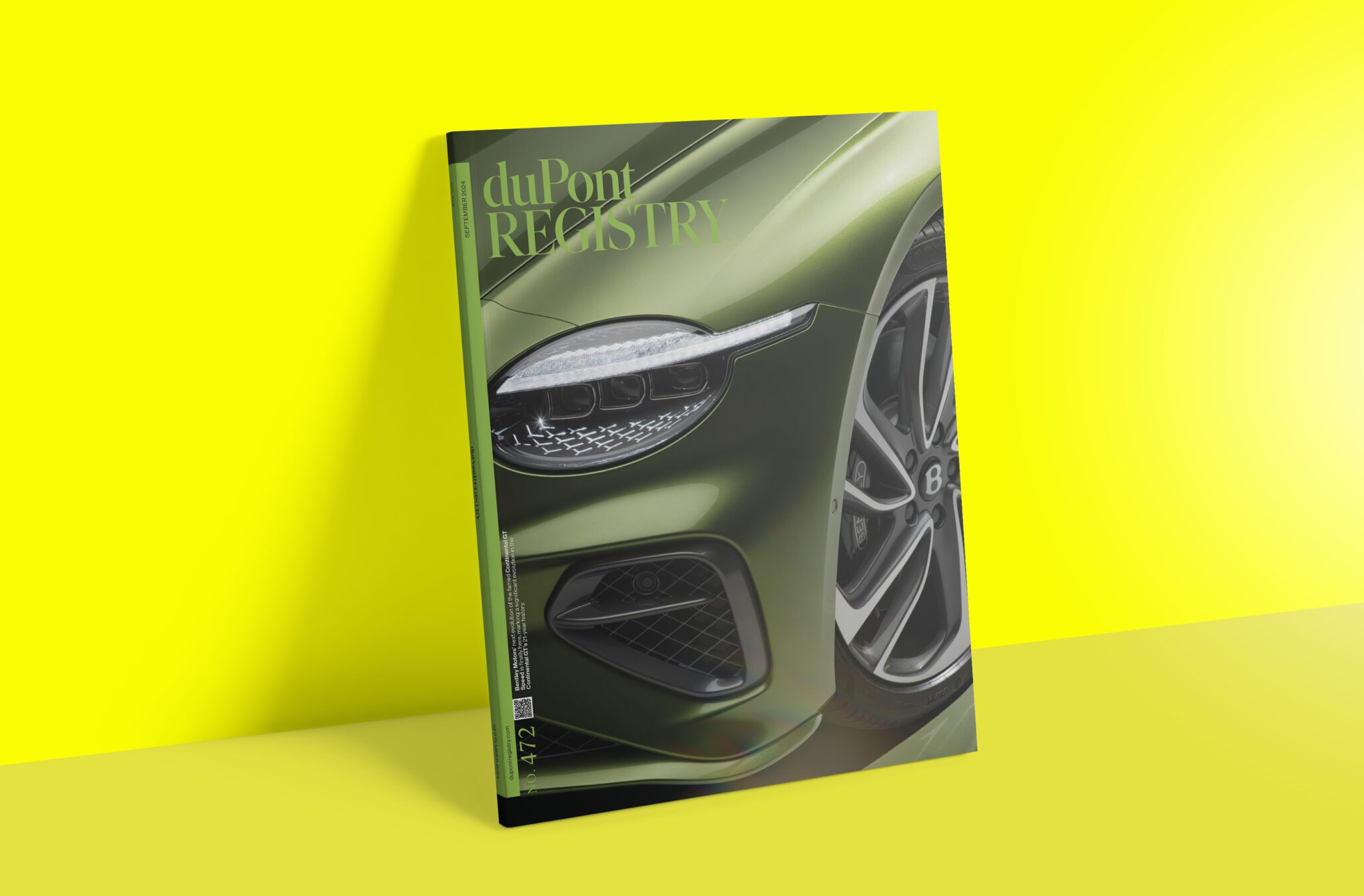 Magazine cover showcasing a close-up of a green luxury car's front wheel and headlight against a bright yellow background, capturing the essence of Upper Echelon design at Pebble Beach Concours d'Elegance.