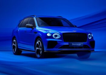 A blue luxury SUV, boasting the sleek design of a Bentayga S, is parked against a matching blue background.