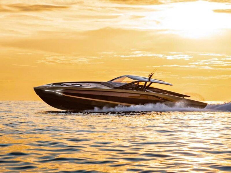 A sleek motorboat speeds across the water at sunset, creating waves and leaving a trail behind, offering a glimpse into the maritime experience akin to luxury yachts gliding effortlessly through serene waters.