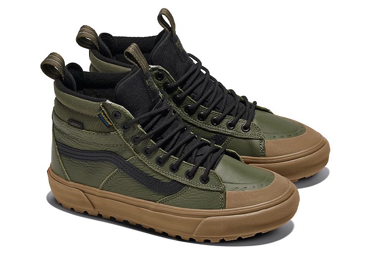 A pair of olive green high-top sneakers with black laces and tan soles, perfect for the cooler months. A standout addition to your Fall Shopping Guide.