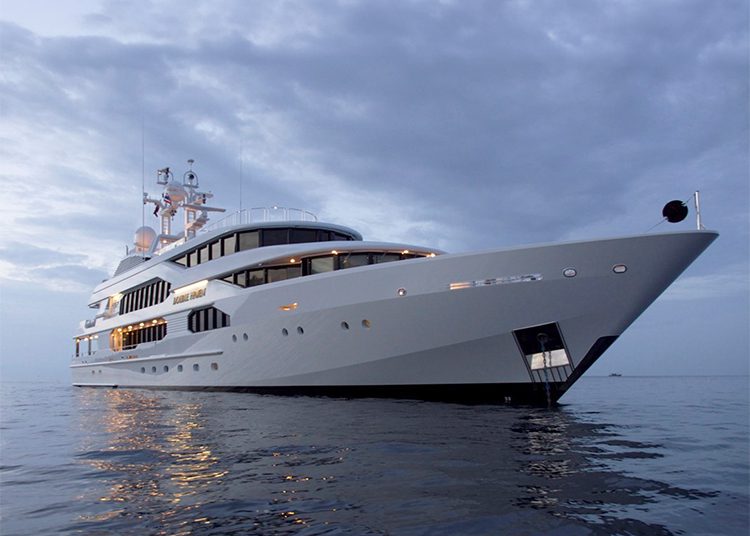 A large luxury yacht is anchored on calm water under a cloudy sky, embodying the elegance and grandeur you can expect at the Fort Lauderdale International Boat Show 2024.