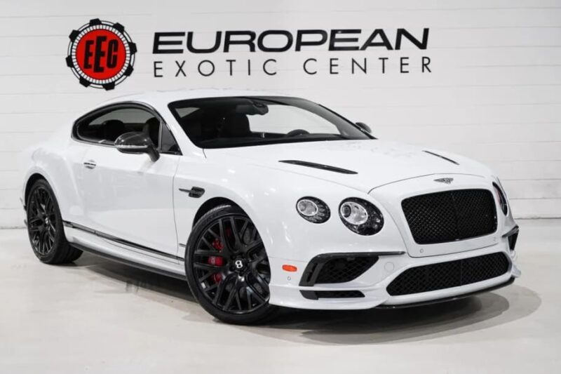 White Bentley Continental GT Coupe, one of the best for sale, stopped inside in front of the wall with "European strange center" The logo and the text.
