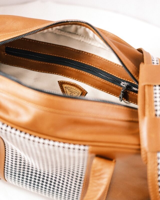 Close-up of an open Walter Leather Bespoke brown leather and houndstooth bag, featuring a visible inner pocket and zipper.