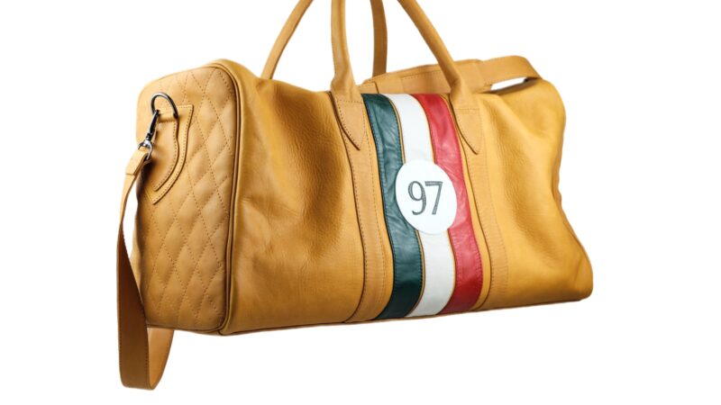 Introducing a tan leather duffel bag with quilted sides, red and green stripes, and the number 97 on the front. Perfect for those who value style in every detail, it's like having custom leather luggage that echoes Walter Leather Bespoke's commitment to quality craftsmanship.