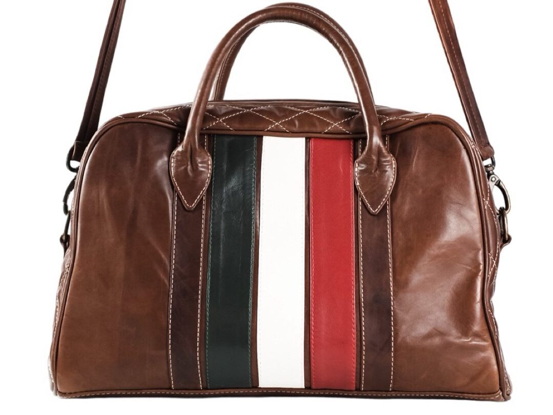 Introducing the Walter Leather Bespoke brown leather duffle bag, featuring red, white, and green vertical stripes and a comfortable shoulder strap. This piece embodies the same attention to detail as jackets tailored to perfection.