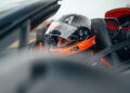 A person wearing a racing helmet sits in a Bugatti W16 Mistral, focused ahead, ready to chase the world record at 282 MPH.