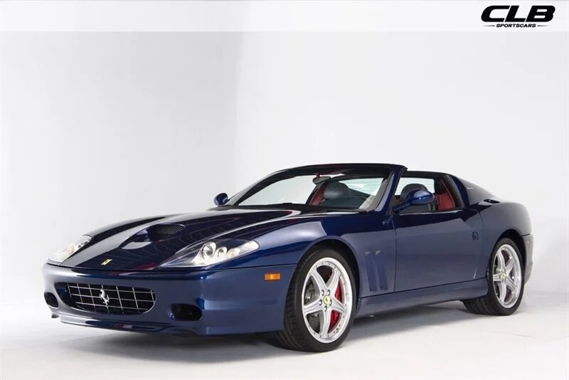 A blue convertible sports car with a sleek design is showcased in a studio setting, offering silver alloy wheels and red brake calipers. Among the best 2000s cars, this model stands out for its classic appeal and performance.