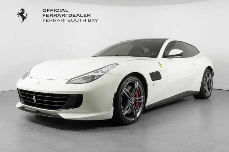 White Ferrari GTC4Lusso featuring a powerful V12 engine is showcased in the showroom with Ferrari South Bay branding on the wall, perfect for those seeking exotic cars for sale.