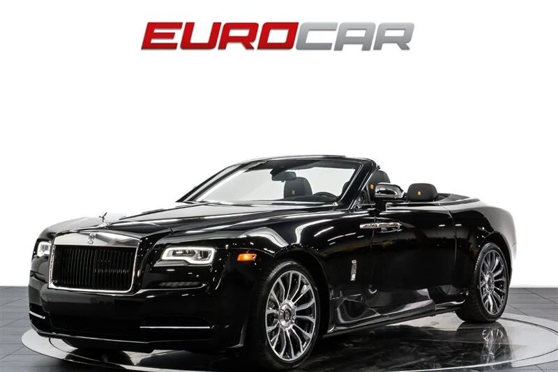 Under the "EUROCAR" sign in the showroom, this shiny black convertible with silver detailing is a true gem among exotic cars, featuring a powerful V12 engine that adds to its allure.