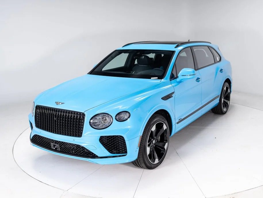 Ultra-Luxe SUV in light blue features a striking black roof, large front grille, and sleek black wheels on a pristine white studio backdrop.