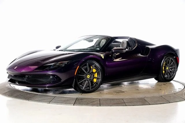 A purple Ferrari convertible sports car with yellow brake calipers, showcasing exotic car colors, is displayed on a circular platform against a white background.