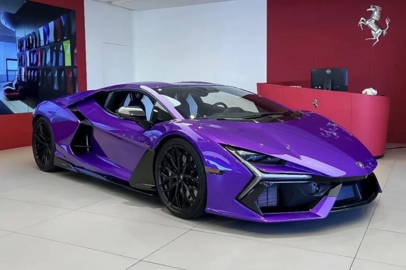 A 2024 Lamborghini Revuelto in a stunning purple hue, showcasing its sleek design, is displayed in the showroom.