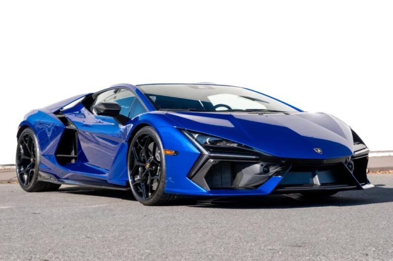 A blue sports car with sleek design and angular features, resembling exotic cars, parked on a gray surface.