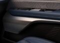 Close-up of the Cadillac Vistiq's car interior door panel, featuring blue leather trim, metallic accents, and a control panel with buttons. This Luxury EV showcases a textured surface that exudes elegance and sophistication.