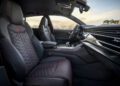 The interior of the Audi RS Q8 Performance boasts black and red leather seats, a sleek dashboard, and a meticulously designed center console, reflecting the exceptional craftsmanship of an expert chassis developer.