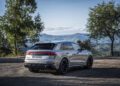 A silver Audi RS Q8 Performance SUV is parked on a gravel surface, offering a scenic view of the mountains and trees in the background, reminiscent of a picturesque drive through Spain.