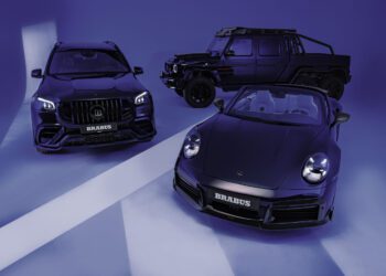 In the Deep Blue Series showroom, three luxury cars—a BRABUS SUV, a BRABUS off-road vehicle, and a convertible sports car—stand majestically in dark hues against a sleek, blue-lit backdrop.
