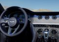 The interior of a luxury car showcases a steering wheel, dashboard with three circular dials, and gear lever, all featuring high-end detailing and finishes—an exquisite display of Mulliner Bespoke craftsmanship at Bentley Rancho Mirage that truly embodies expressions of texture.