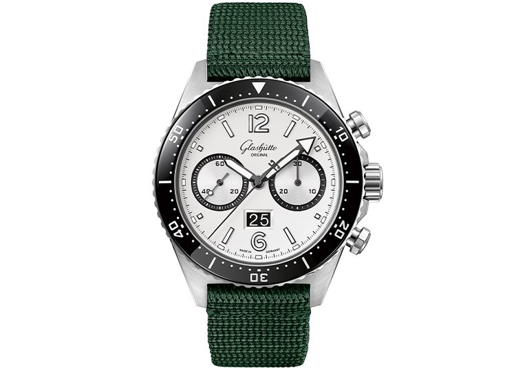 This luxury watch, featured in the duPont REGISTRY guide, boasts a stainless steel build with a white dial, green fabric strap, and black bezel. It includes chronograph subdials, a date window at 6 o'clock, and luminous hands for an elegant yet functional design.