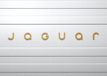 The image showcases the Jaguar logo, with the word "jaguar" elegantly rendered in gold letters on a textured silver-gray surface, embodying the brand identity's sleek sophistication.