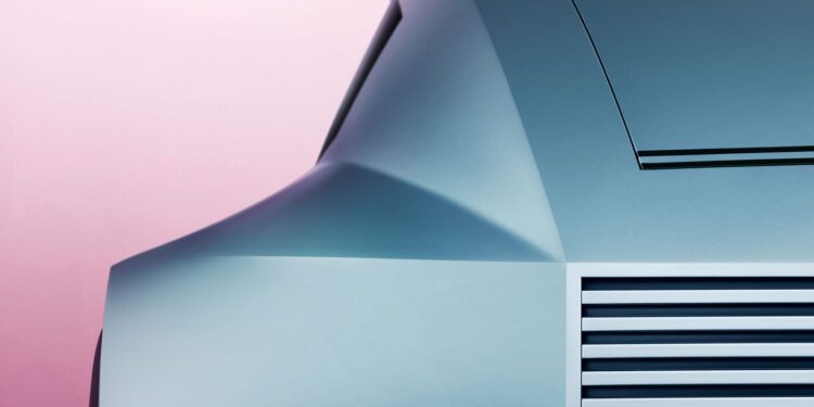 Close-up of a Jaguar Vision Design Concept showing off its futuristic car with smooth, angular design and horizontal vents against a pink gradient background—a striking teaser image for what's to come.