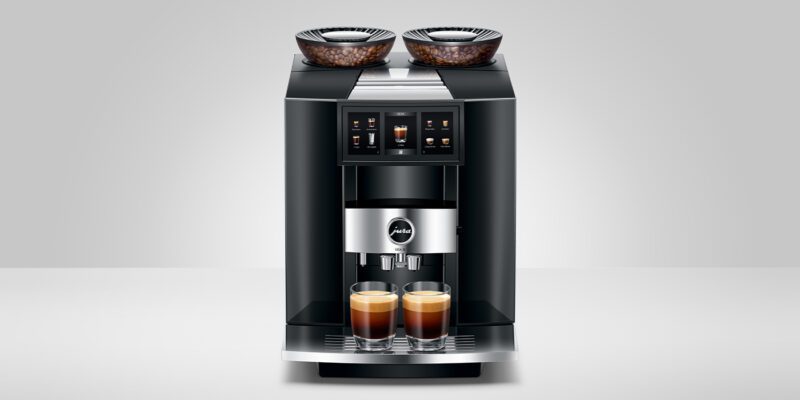 A modern coffee machine with digital controls and two glass cups filled with coffee makes the perfect holiday gift for coffee aficionados seeking luxury machines.