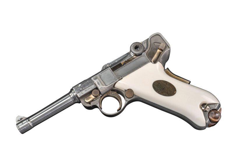 Silver and white ornate pistol with detailed engravings and a smooth handle.