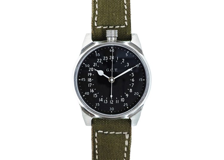 A silver wristwatch, featured in the Luxury Watch Guide, boasts a black face with white hour and minute markers, complemented by a green fabric strap. The time elegantly displays 10:08.