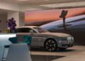 A sleek, gray Rolls-Royce is parked indoors near blue chairs in the new Abu Dhabi showroom, with a large digital screen showcasing a close-up of the car's hood ornament in the background.