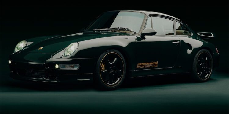 A dark green 993 Turbo by Porsche is parked in a dimly lit setting, showcasing a side and front view with glowing headlights, exuding an air of exclusivity reminiscent of Aimé Leon Dore's refined aesthetic.